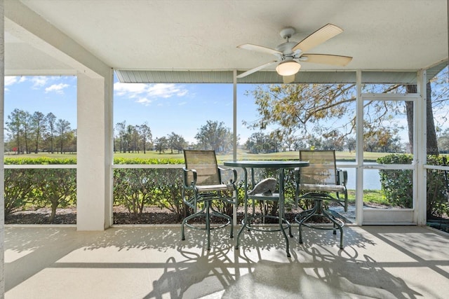 sunroom / solarium featuring ceiling fan, a water view, and a healthy amount of sunlight