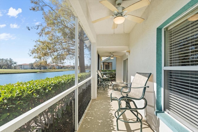 balcony featuring a water view and ceiling fan