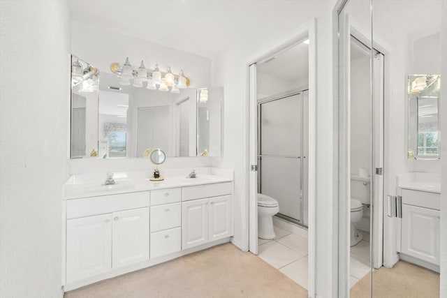 bathroom featuring tile patterned flooring, vanity, toilet, and walk in shower