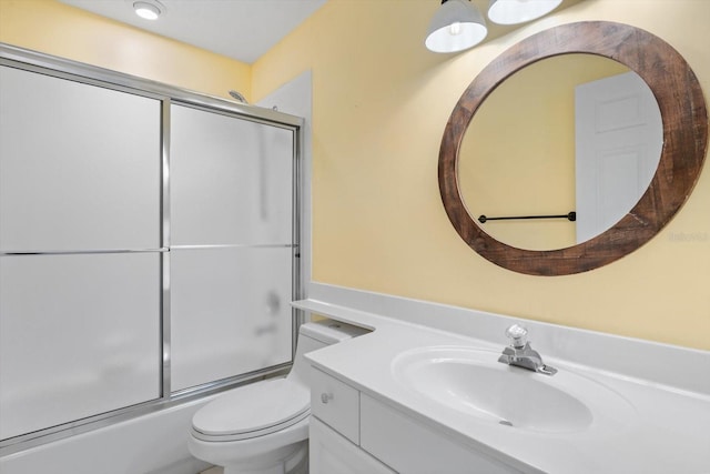 full bathroom with toilet, combined bath / shower with glass door, and vanity