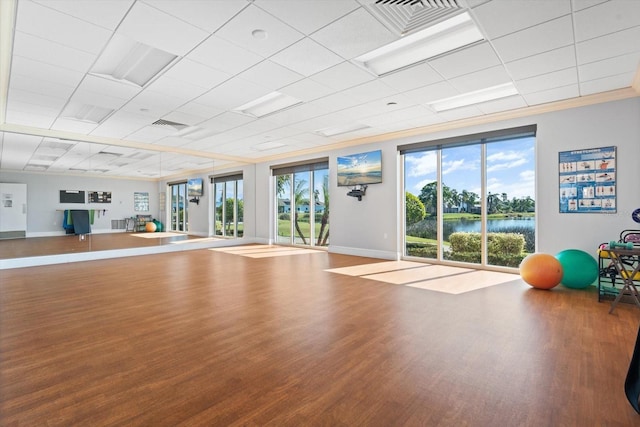 workout area featuring wood-type flooring and ornamental molding