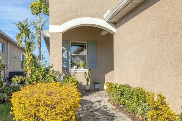 view of exterior entry featuring central air condition unit