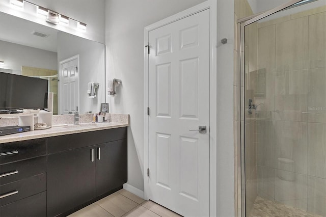 bathroom with tile patterned floors, vanity, and walk in shower