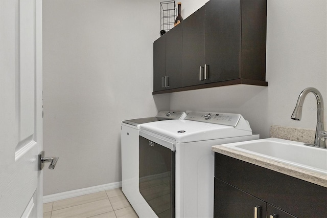 washroom featuring sink, light tile patterned flooring, cabinets, and independent washer and dryer