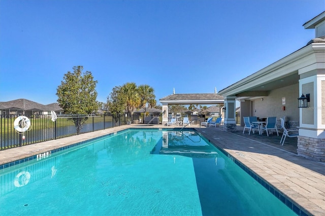 view of pool featuring a patio and a water view