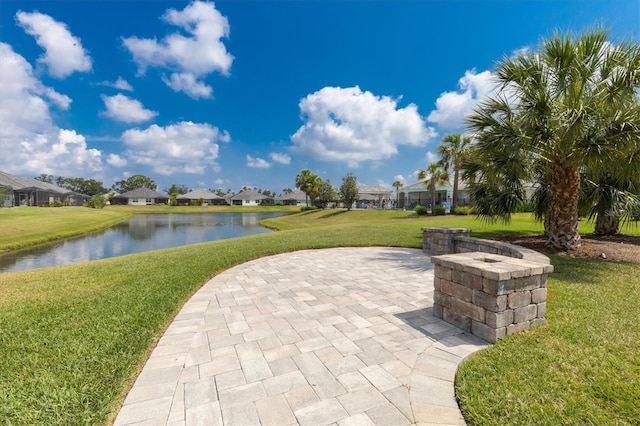 view of community with a yard, a water view, and a patio