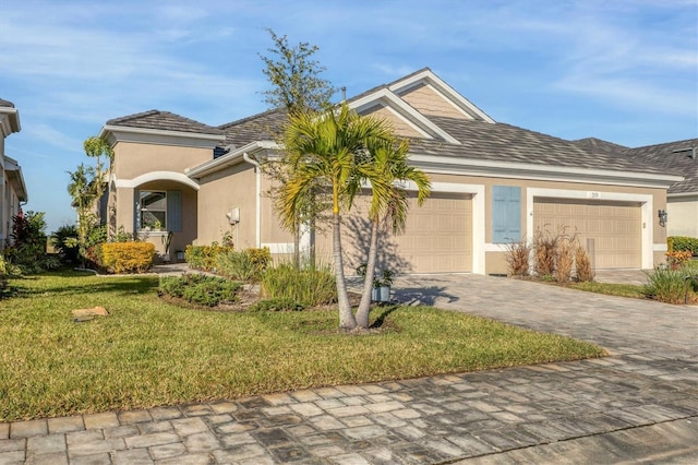 3115 Trustee Ave, Sarasota, FL 34243 - view of front of home featuring stucco siding, an attached garage, a front yard, and driveway