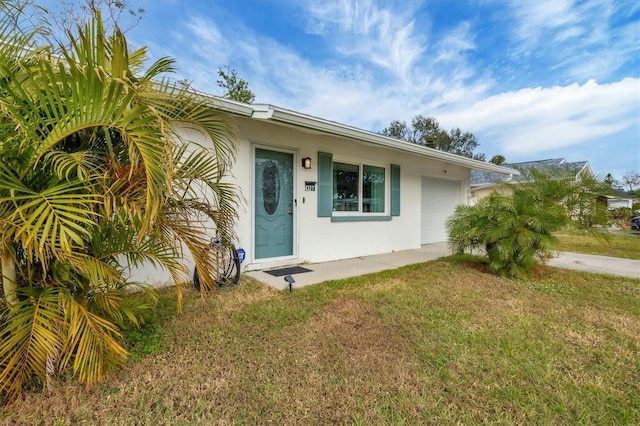 doorway to property with a yard and a garage