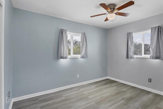 empty room with hardwood / wood-style flooring and ceiling fan