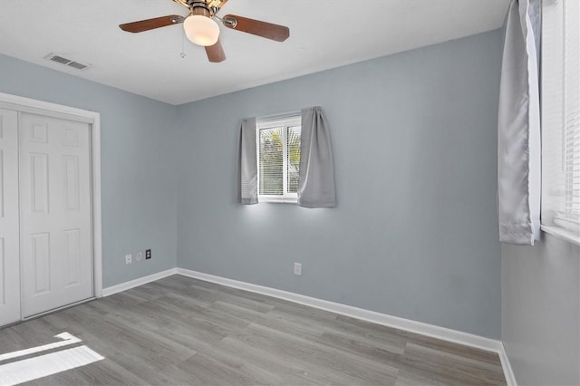 unfurnished bedroom with ceiling fan, a closet, and light hardwood / wood-style flooring