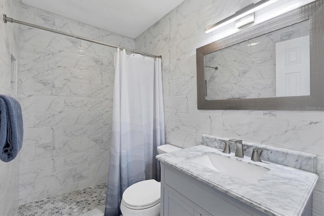 bathroom with curtained shower, vanity, tile walls, and toilet