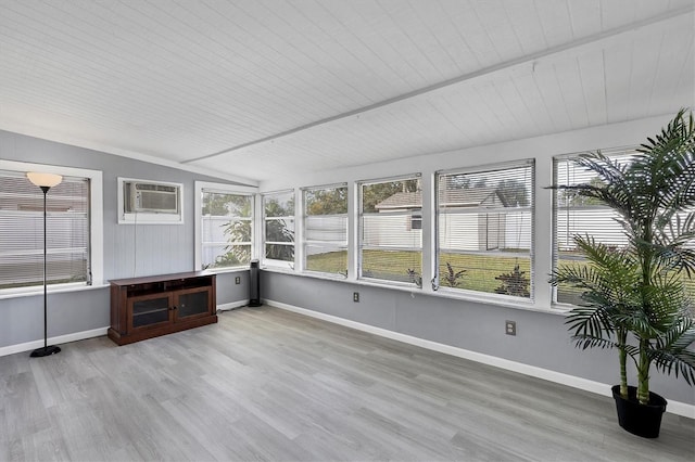 unfurnished sunroom with wooden ceiling, an AC wall unit, a wealth of natural light, and vaulted ceiling