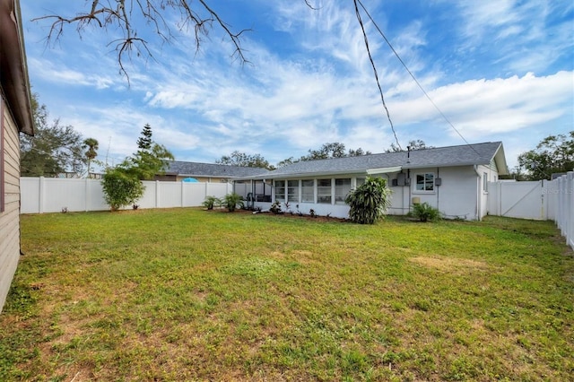 back of house with a sunroom and a yard