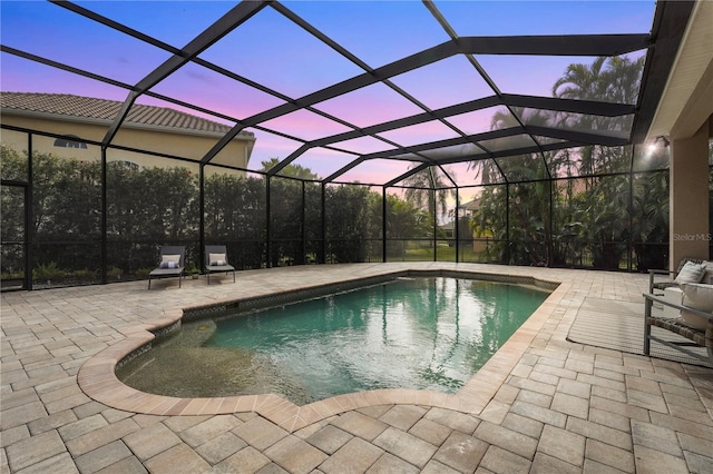 pool at dusk featuring glass enclosure, an outdoor pool, and a patio