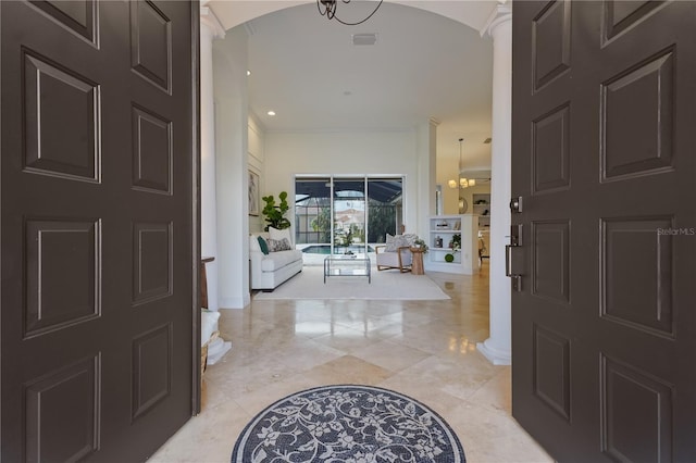 foyer entrance with an inviting chandelier and arched walkways