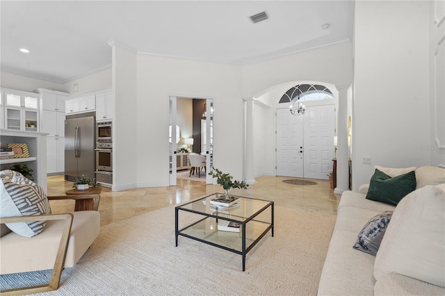 living area with baseboards, visible vents, crown molding, and ornate columns