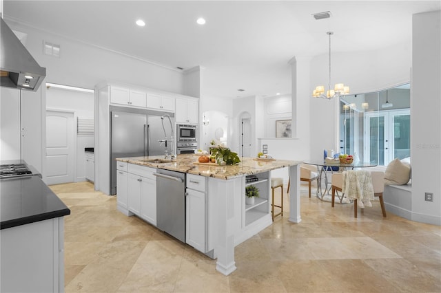 kitchen with built in appliances, open shelves, ventilation hood, and white cabinetry