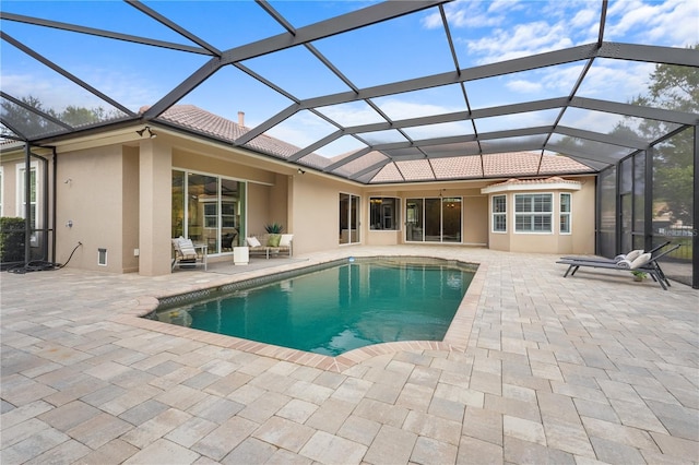 pool with a patio area and glass enclosure