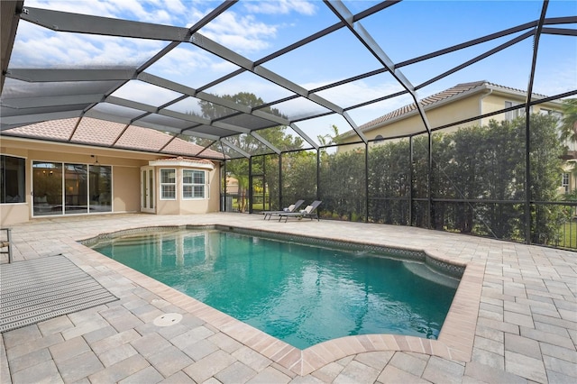 pool with a patio and glass enclosure