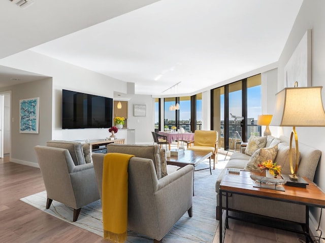 living room with floor to ceiling windows and light wood-type flooring