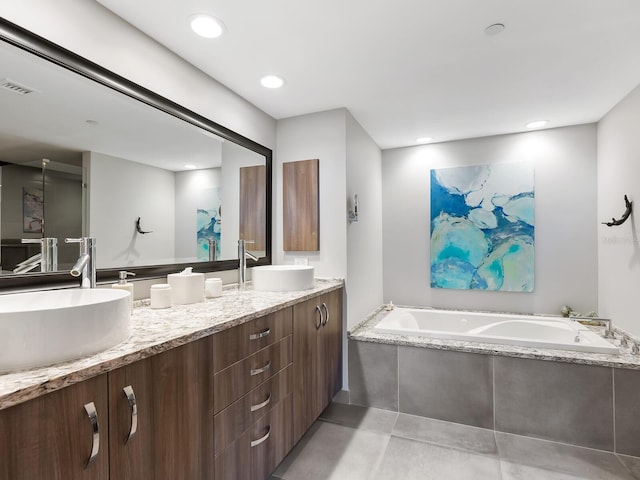 bathroom featuring vanity and tiled tub