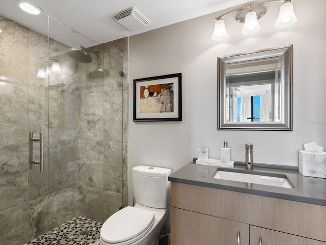 bathroom with a shower with door, vanity, and toilet