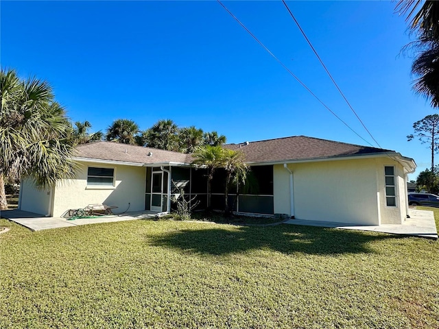 rear view of property with a sunroom and a lawn