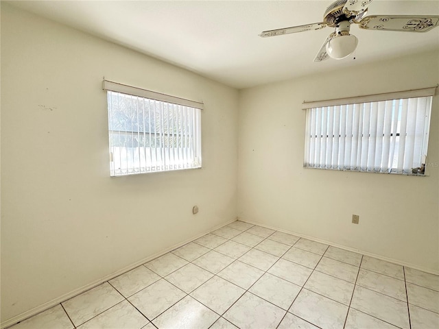 tiled empty room featuring ceiling fan