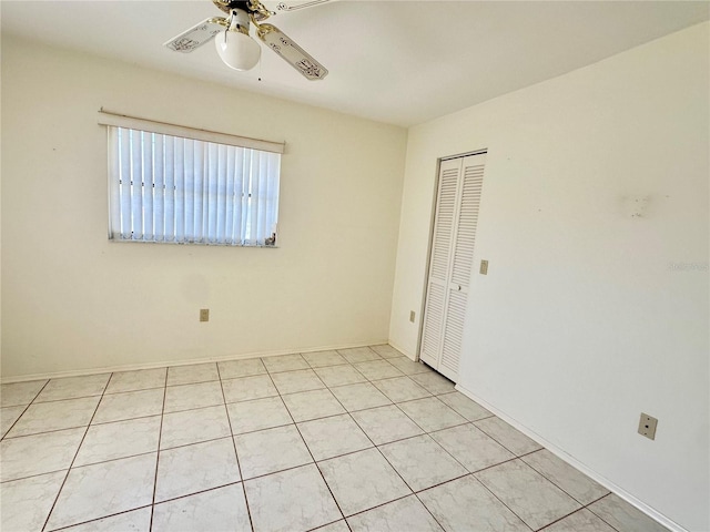 unfurnished room with ceiling fan and light tile patterned floors