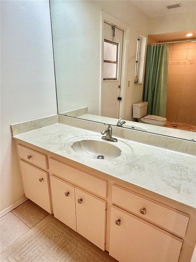 bathroom featuring tile patterned flooring, vanity, a shower with shower curtain, and toilet