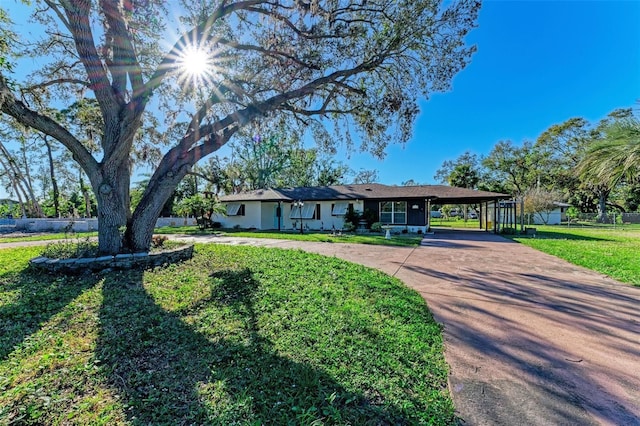 ranch-style house with a front yard and a carport