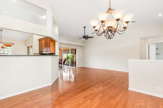 unfurnished living room featuring ceiling fan with notable chandelier, high vaulted ceiling, and light hardwood / wood-style flooring