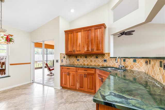 kitchen featuring light tile patterned flooring, decorative light fixtures, tasteful backsplash, sink, and ceiling fan