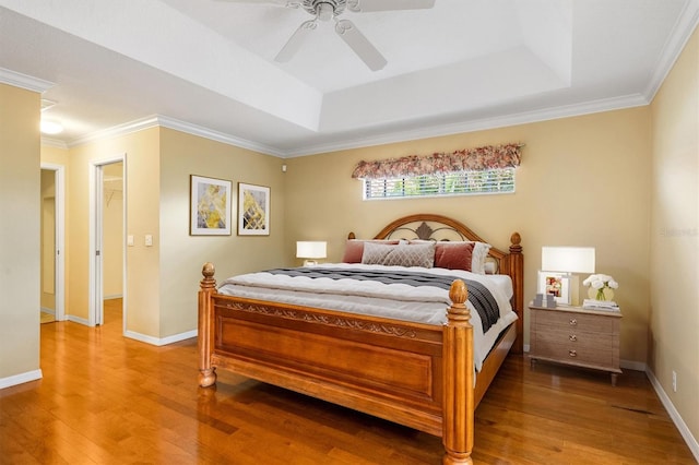 bedroom featuring hardwood / wood-style floors, a tray ceiling, and ceiling fan