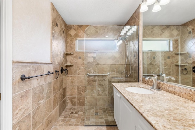 bathroom with vanity and a tile shower