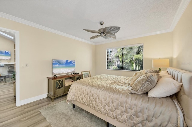 bedroom featuring a textured ceiling, light wood-style flooring, and ornamental molding