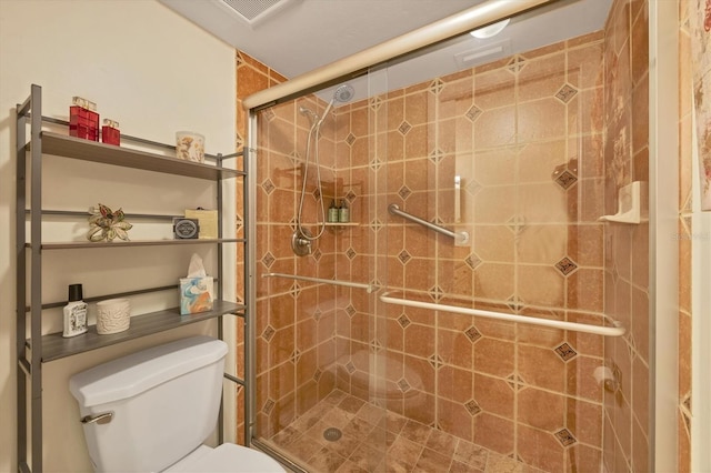 bathroom featuring toilet, visible vents, and a stall shower