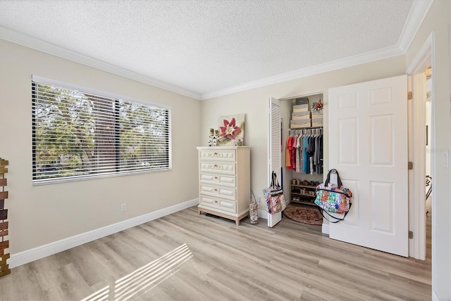 bedroom featuring light wood-type flooring, a textured ceiling, and ornamental molding