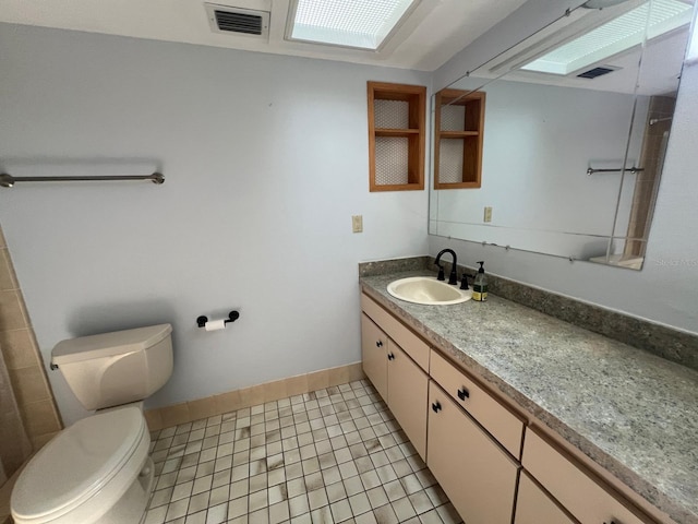 bathroom with tile patterned flooring, vanity, and toilet