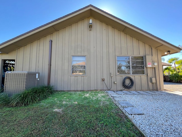 view of property exterior with central air condition unit and a yard