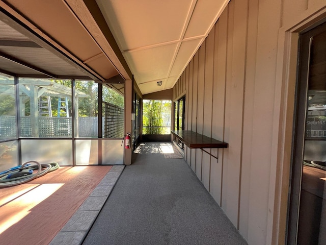 unfurnished sunroom featuring vaulted ceiling