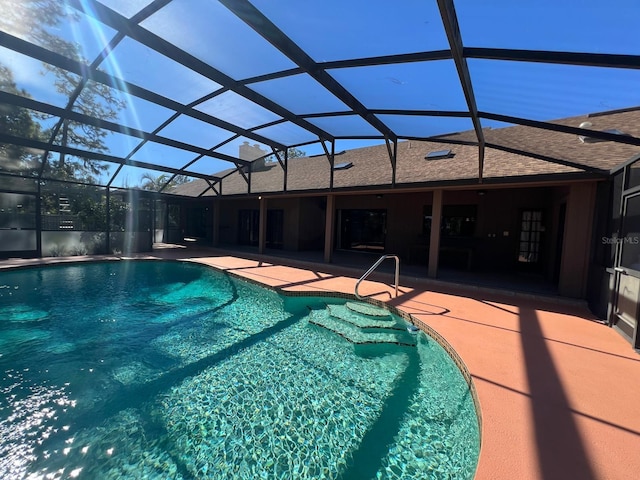 view of swimming pool with glass enclosure and a patio area