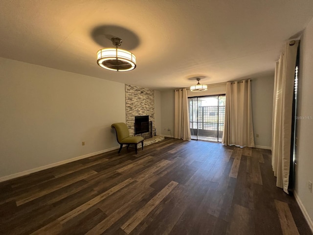 unfurnished room with a wood stove and dark wood-type flooring