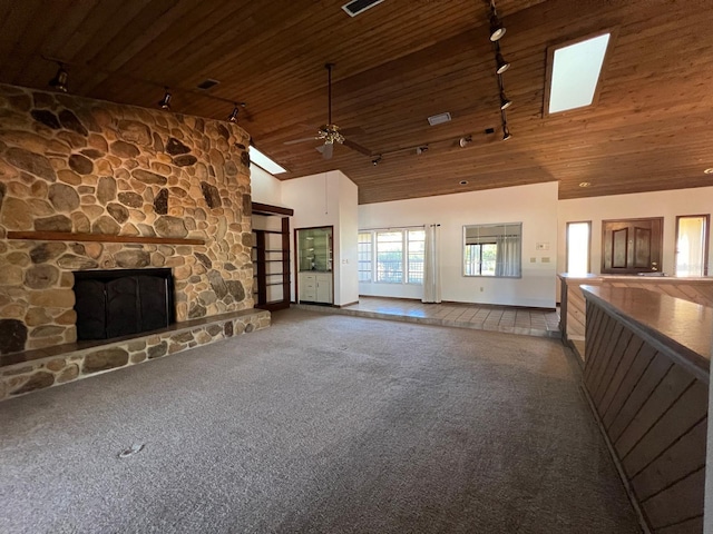 unfurnished living room featuring wooden ceiling, high vaulted ceiling, a stone fireplace, rail lighting, and carpet floors