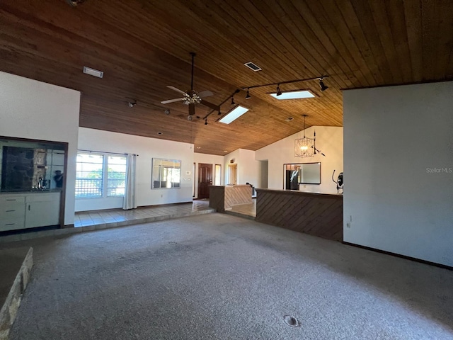 unfurnished room with vaulted ceiling with skylight, ceiling fan with notable chandelier, wooden ceiling, and carpet