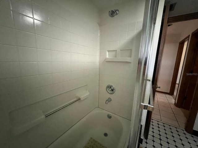 bathroom featuring tile patterned flooring and tiled shower / bath