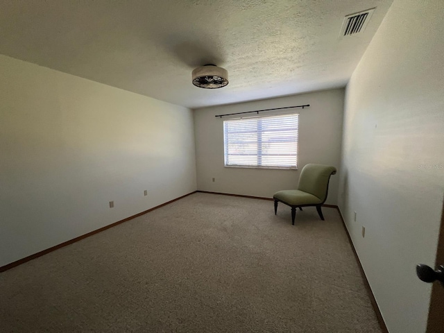 unfurnished room featuring light carpet and a textured ceiling