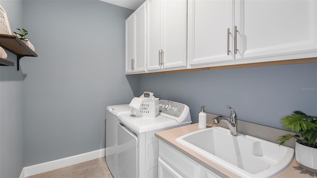 laundry area featuring washer and dryer, cabinets, and sink