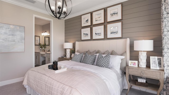 bedroom with connected bathroom, a notable chandelier, crown molding, wood walls, and carpet floors