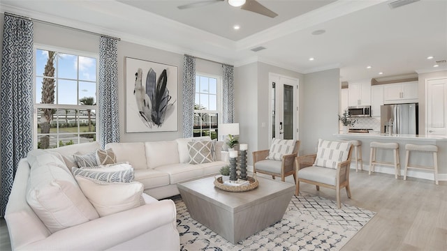 living room featuring light hardwood / wood-style flooring, ceiling fan, and ornamental molding